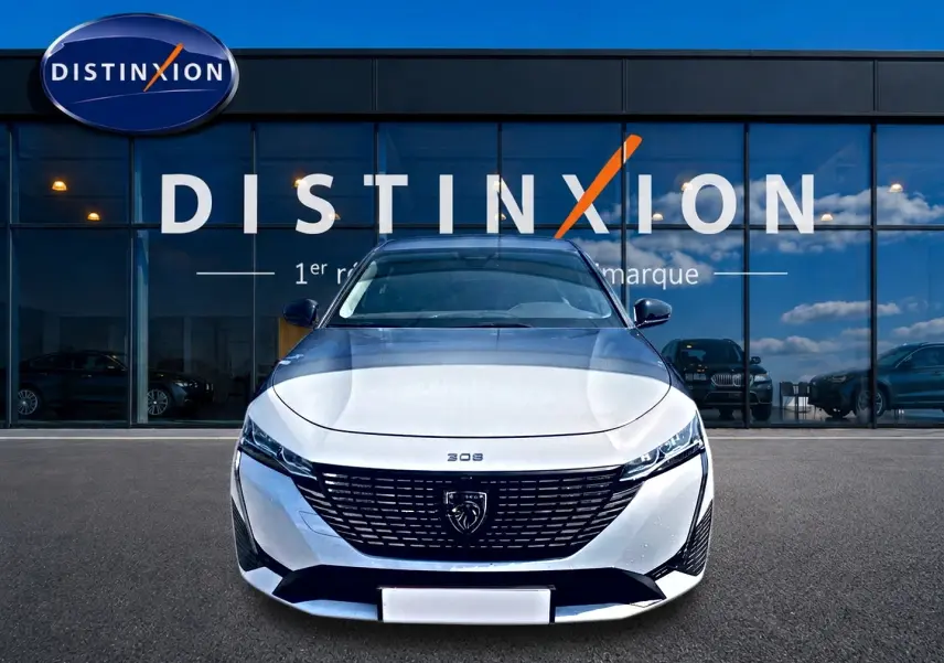 Vue frontale d'une Peugeot 308 SW blanche 2025 avec calandre noire et logo lion distinctif.