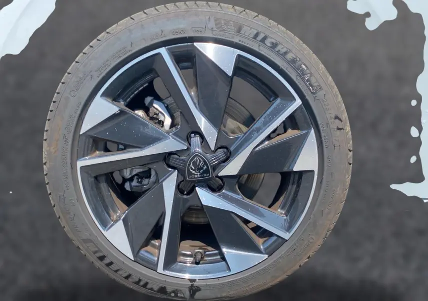 Gros plan sur la jante alu noire et argentée du Peugeot 308 SW 2025 avec logo central distinctif.