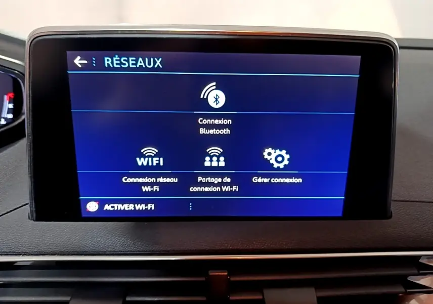 Écran tactile central affichant les options réseau Bluetooth et Wi-Fi dans un Peugeot 5008 gris clair, vue intérieure frontale.