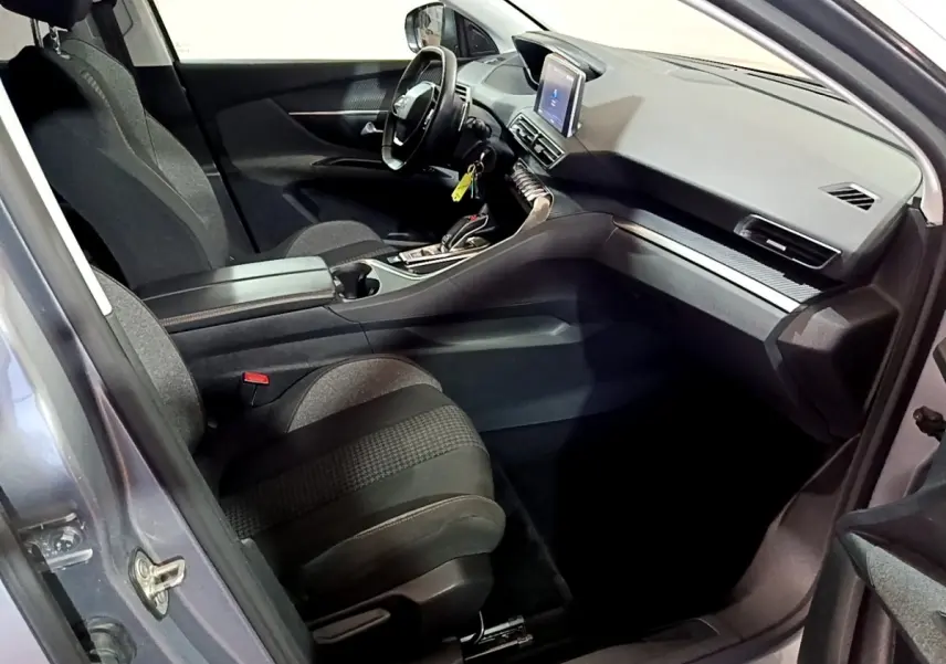 Vue intérieure côté conducteur du Peugeot 5008 gris clair 2020, mettant en valeur le tableau de bord et l'écran tactile central.