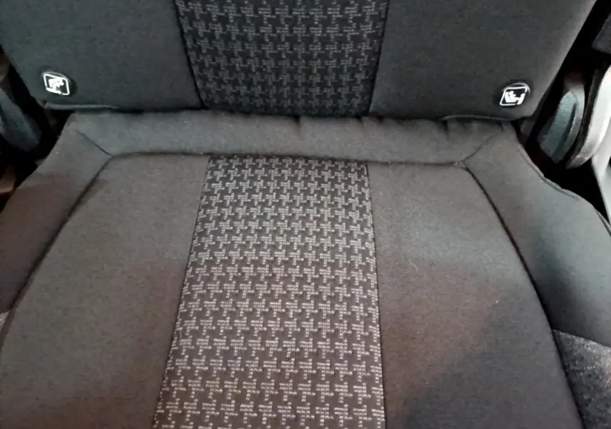 Gros plan sur le siège individuel arrière gris foncé du Peugeot 5008 avec logos Isofix visibles sur le dossier.