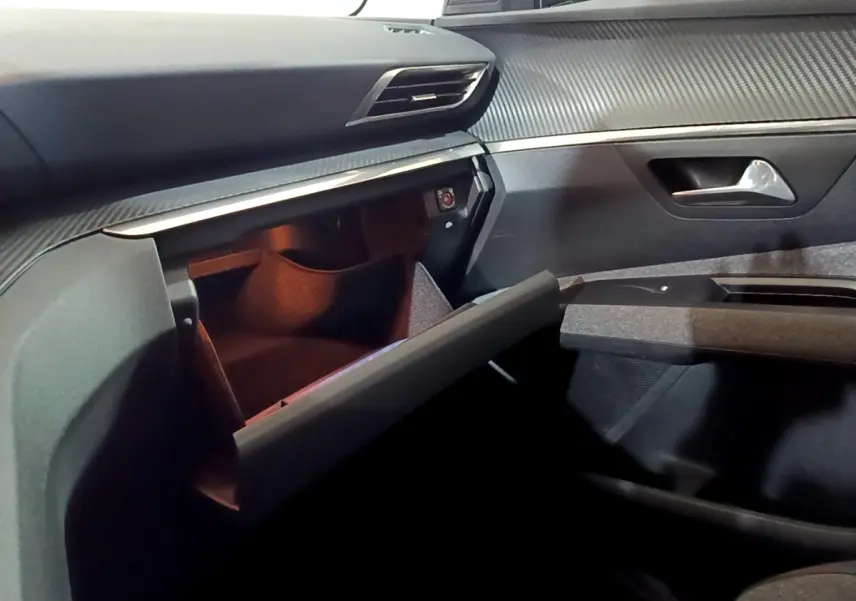 Intérieur du Peugeot 5008 2020, vue côté passager avec boîte à gants ouverte et tableau de bord gris texturé.