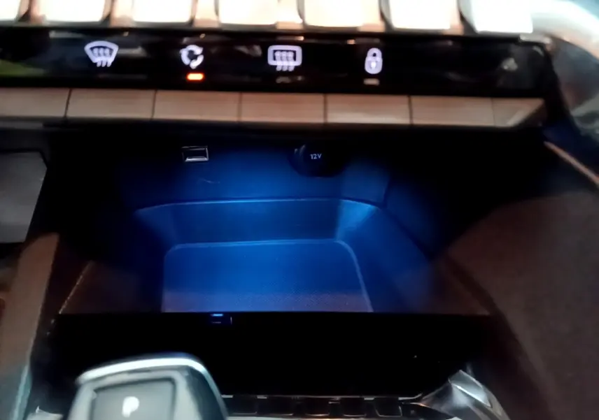 Gros plan intérieur sur la console centrale du Peugeot 5008 gris clair, avec levier de boîte automatique et prises USB et 12V.