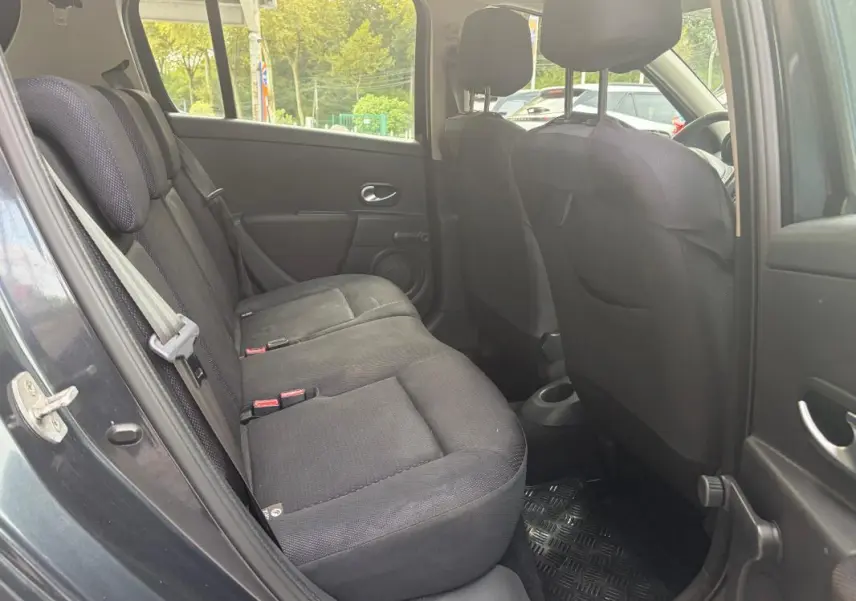 Vue intérieure côté arrière gauche de la Renault Clio III gris, montrant les sièges arrière en tissu noir.