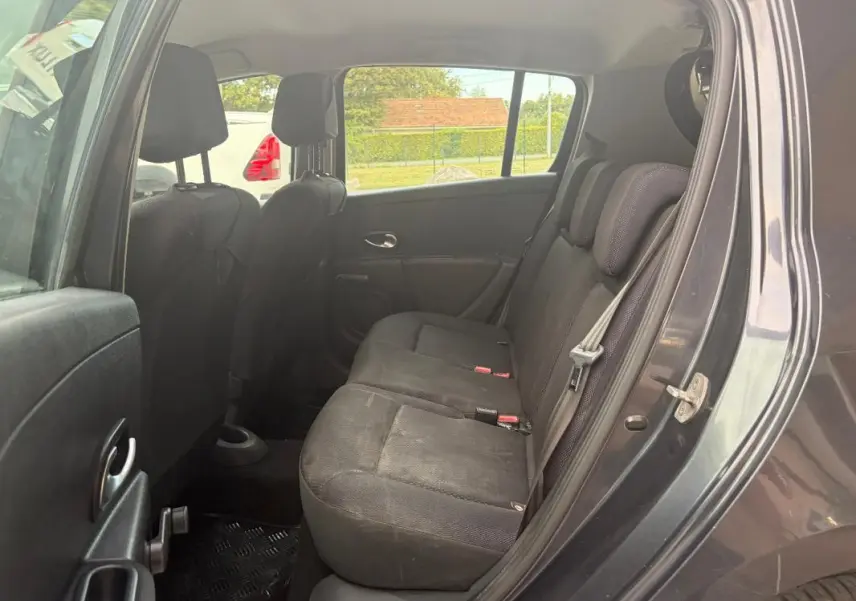 Vue intérieure côté arrière droit de la Renault Clio III gris 2005, montrant les sièges arrière en tissu noir.
