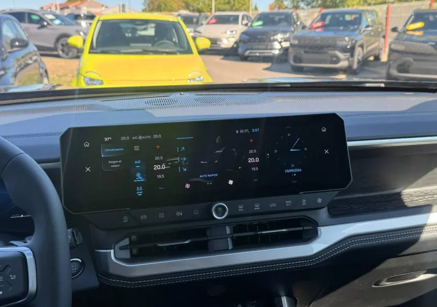 Vue intérieure du tableau de bord numérique du Jeep Compass 2026 avec écran tactile large et commandes climatisation visibles.
