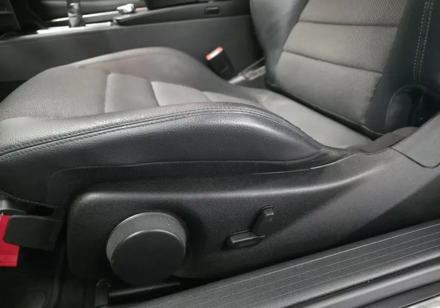 Gros plan sur le siège conducteur noir en similicuir de la Mercedes Classe E Coupé E 200, avec réglages manuels visibles.