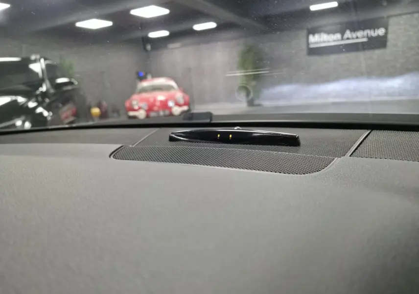 Vue intérieure du tableau de bord gris d'une Mercedes Classe E Coupé E 200 BlueEfficiency 2012 avec haut-parleur central.