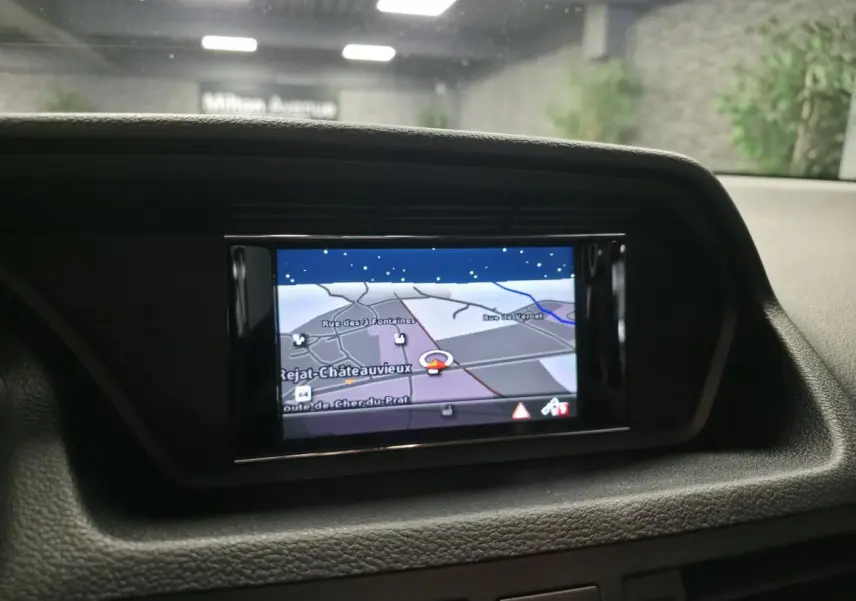 Écran de navigation couleur intégré au tableau de bord d'une Mercedes Classe E Coupé 2012, intérieur noir.