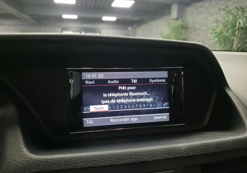 Écran central de navigation et audio affichant la connexion Bluetooth dans une Mercedes Classe E Coupé gris, vue intérieure frontale.