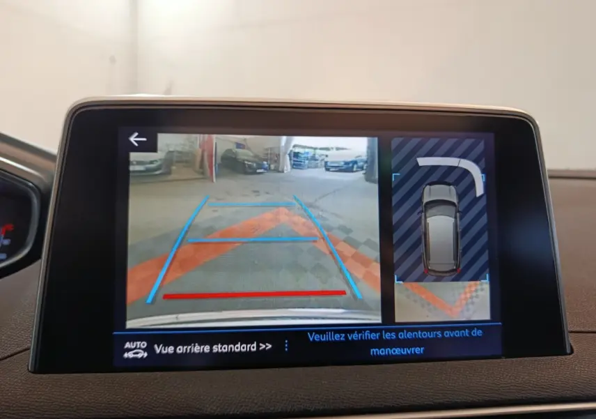 Écran tactile intérieur montrant la caméra de recul et l’aide au stationnement du Peugeot 3008 blanc.