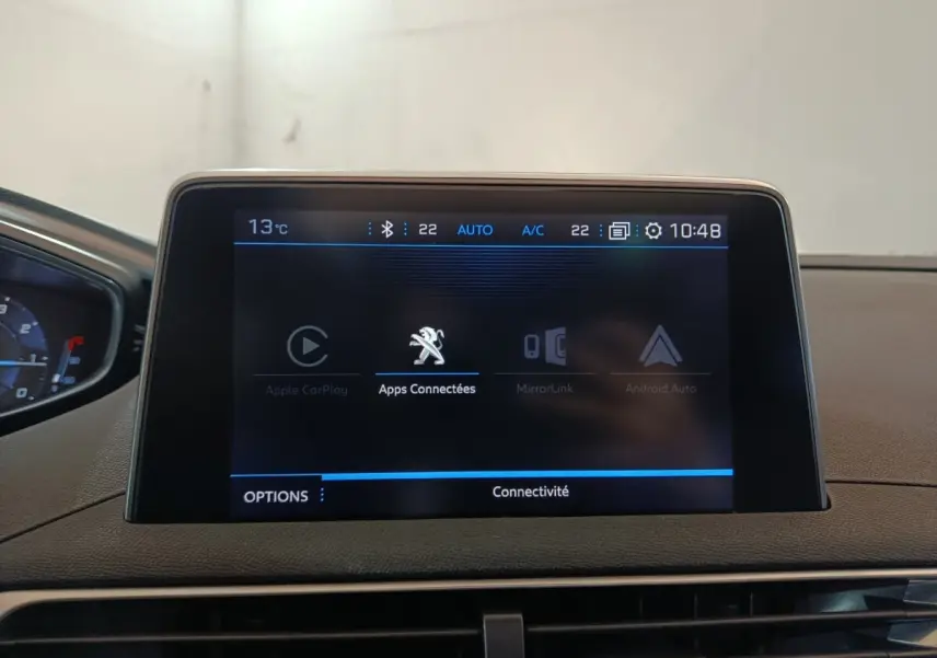 Écran tactile central affichant les options de connectivité dans l’habitacle du Peugeot 3008 blanc, vue de face.