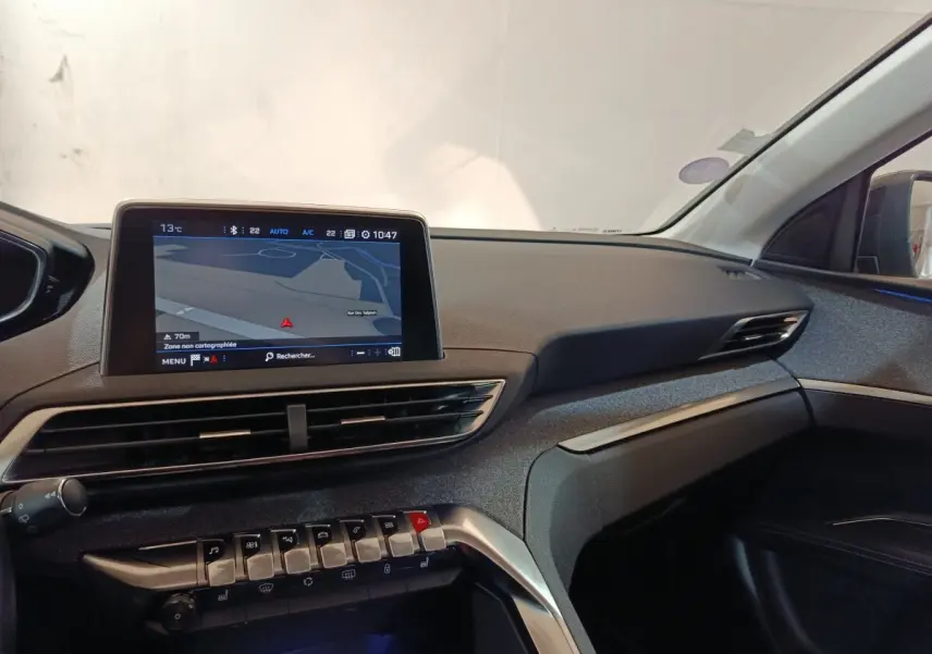 Vue intérieure côté passager du tableau de bord du Peugeot 3008 blanc avec écran tactile de navigation et commandes piano.