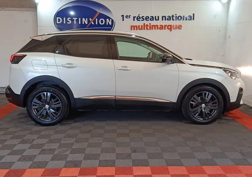Profil côté droit d’un Peugeot 3008 blanc 2019 Puretech Allure avec jantes noires dans un showroom intérieur.
