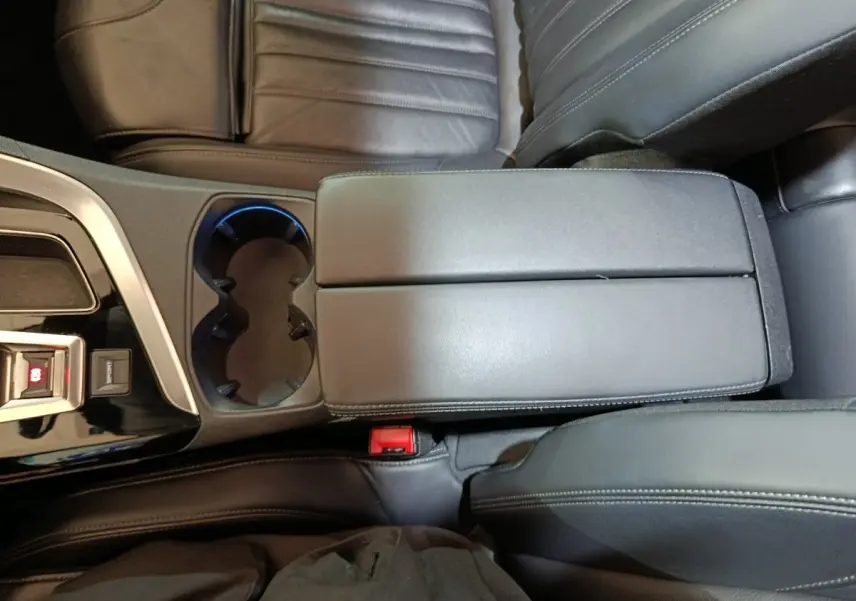 Vue plongeante sur l'accoudoir central noir et porte-gobelets du Peugeot 3008 Puretech 130 Essence 2019.