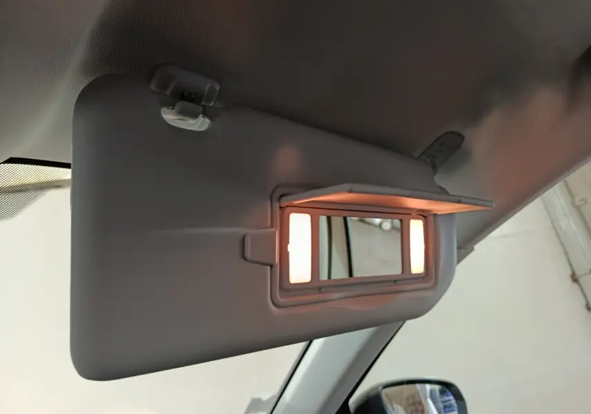 Miroir de courtoisie éclairé sur pare-soleil côté conducteur dans un Peugeot 3008 blanc, vue intérieure rapprochée.