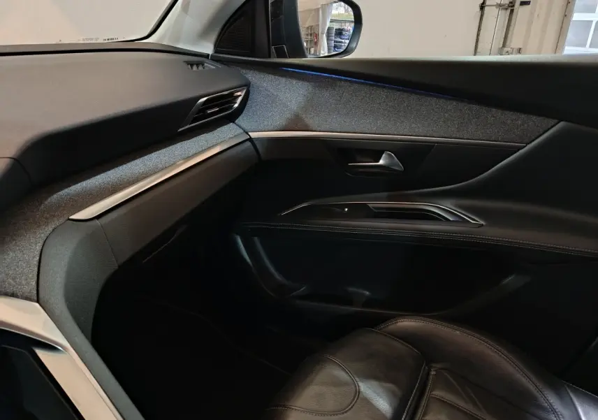 Vue intérieure côté passager du Peugeot 3008 blanc, mettant en valeur la porte et le siège en cuir noir.
