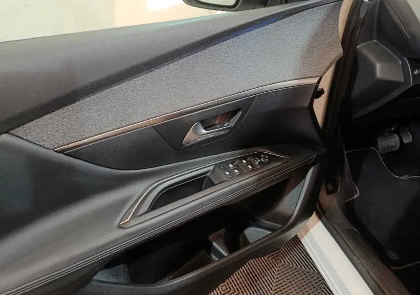 Vue intérieure côté conducteur de la porte noire avec commandes électriques sur Peugeot 3008 blanc 2019.