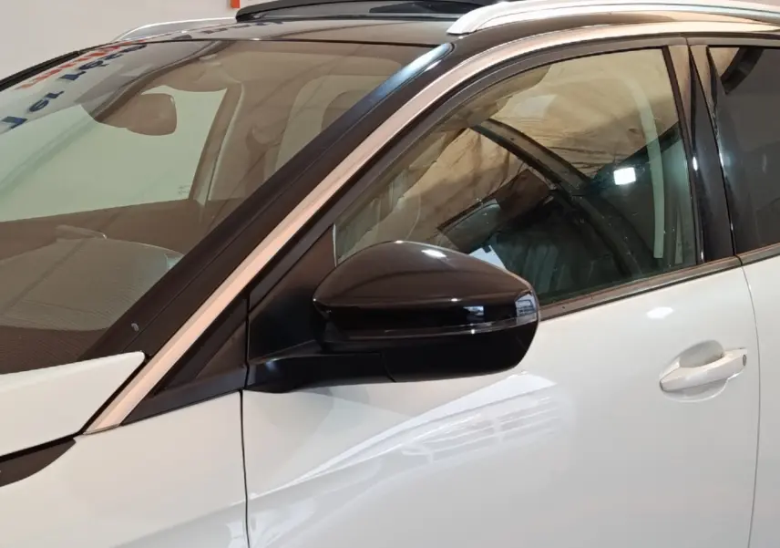 Vue côté gauche rapprochée d’un Peugeot 3008 blanc, mettant en valeur le rétroviseur noir et la poignée de porte.