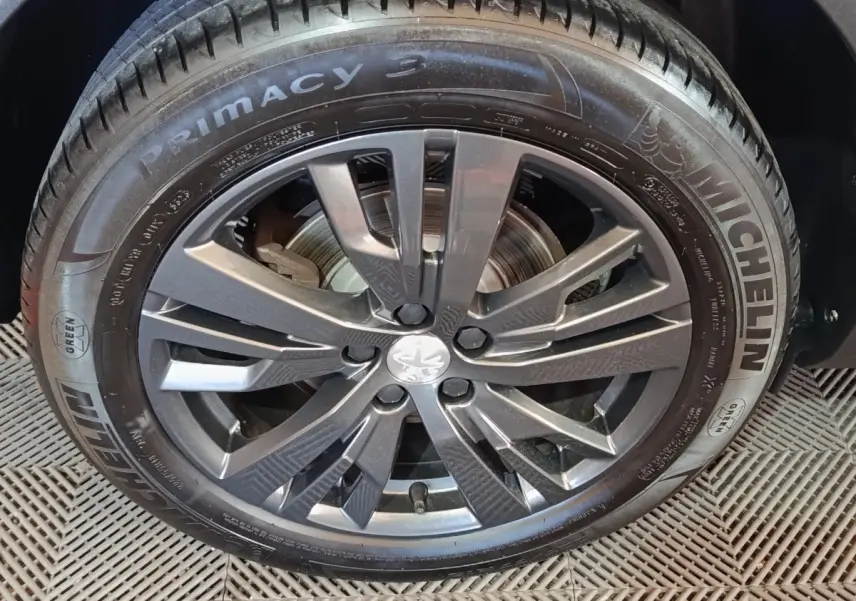 Gros plan sur la roue avant droite du Peugeot 3008 blanc, jante alliage gris foncé et pneu Michelin Primacy 3.