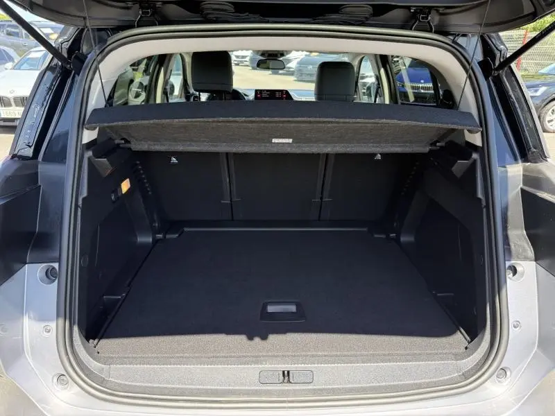 Coffre ouvert vu de l'arrière du Citroën C5 Aircross gris acier, avec cache-bagages et sièges arrière visibles.