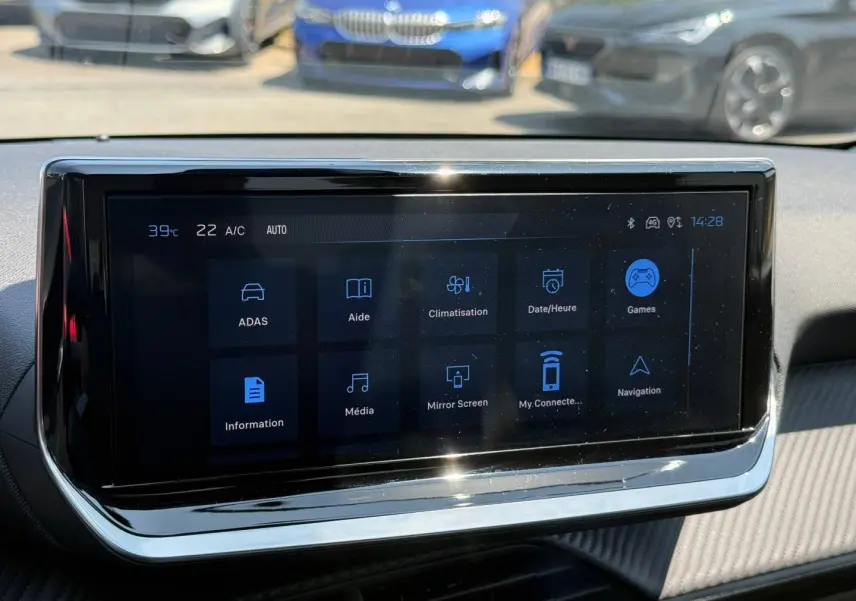 Écran tactile multifonction du tableau de bord de la Peugeot 208 gris Artense, avec menu affiché en intérieur.