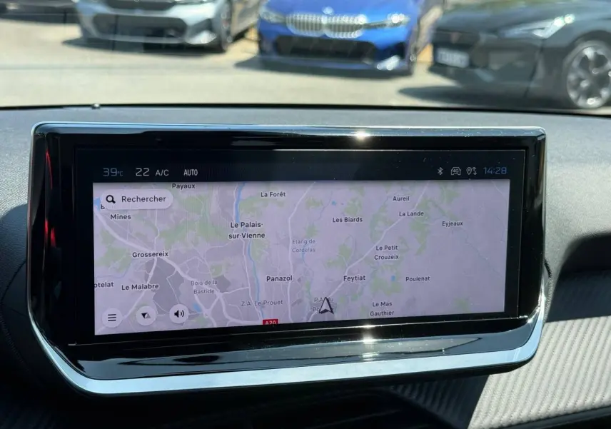 Vue intérieure centrée sur l'écran tactile du système de navigation du Peugeot 208 gris Artense 2025.