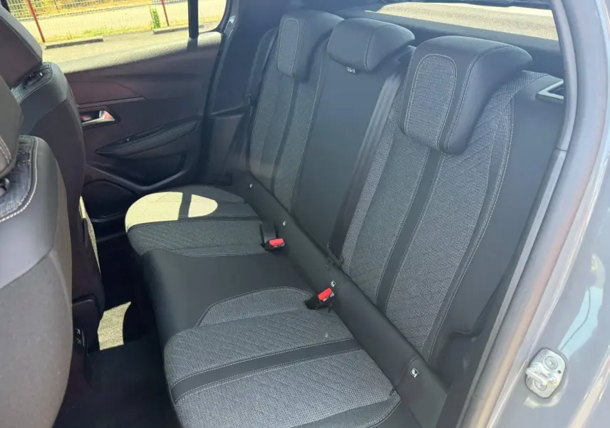 Vue intérieure côté droit sur la banquette arrière tissu gris et noir de la Peugeot 208 1.2 100ch Allure 2025 gris Artense.