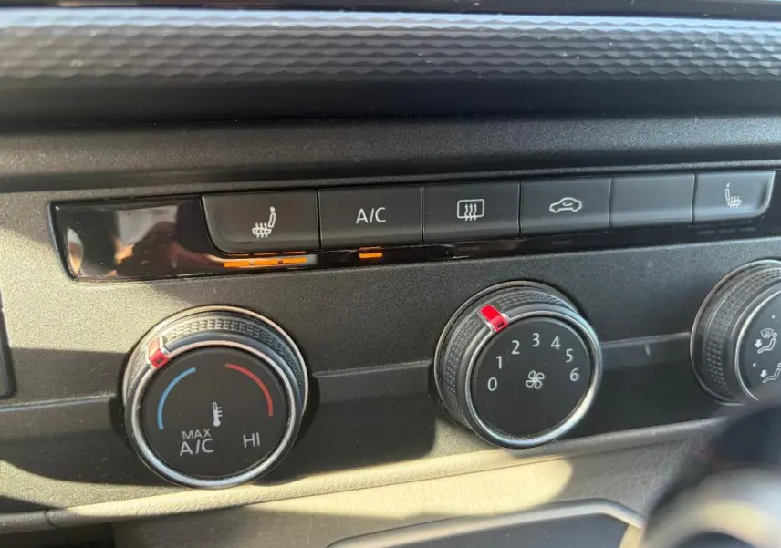 Gros plan sur les commandes de climatisation et sièges chauffants du Volkswagen Transporter blanc, version 2020.