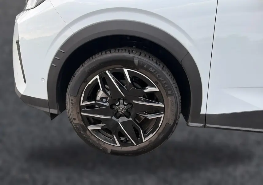 Gros plan sur la roue avant droite noire et argentée du Peugeot 5008 blanc Hybrid 145 allure e-dcs6 2025.