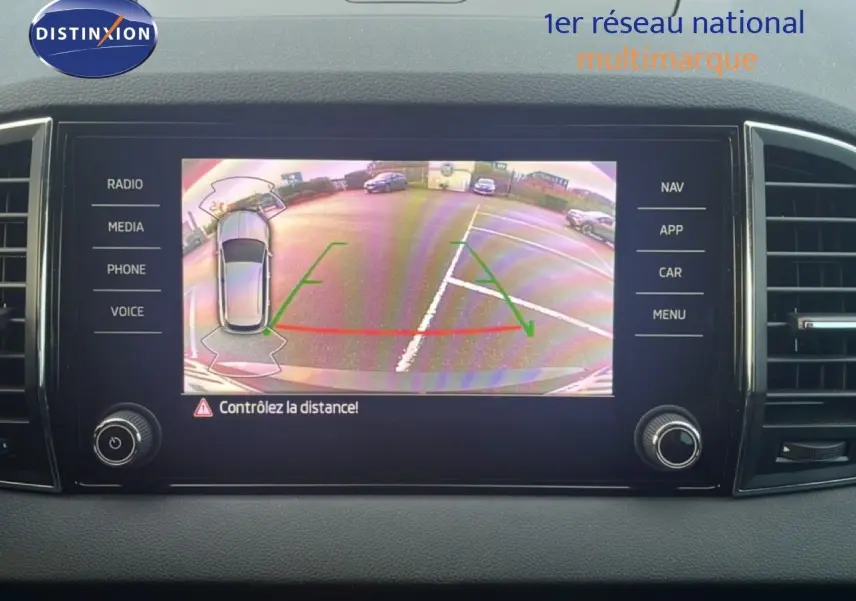 Écran multimédia montrant la caméra de recul d'une Skoda Karoq noir magic metal en stationnement arrière.