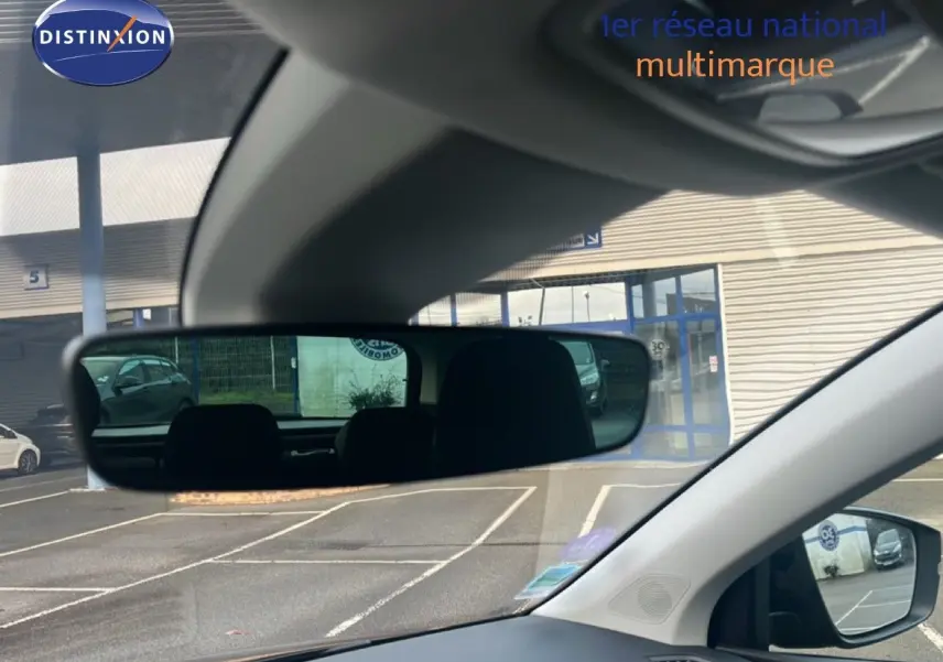 Vue intérieure du poste de conduite du Skoda Karoq noir Magic Metal, avec rétroviseur central et extérieur visibles.