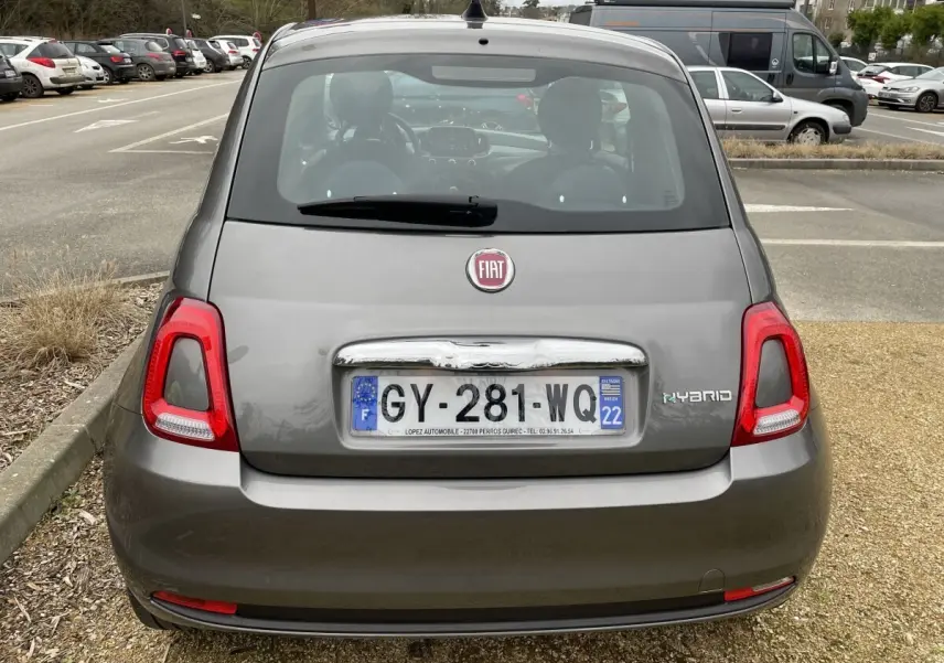 Vue arrière d'une Fiat 500 hybride gris foncé avec feux arrière rouges et plaque d'immatriculation française visible.