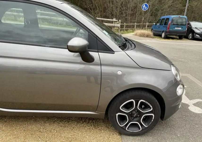 Vue de profil côté gauche d'une FIAT 500 Hybrid gris foncé avec jante alliage au design distinctif.