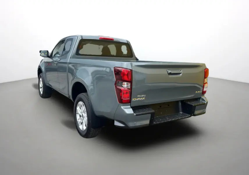 Vue 3/4 arrière gauche d'un Isuzu D-MAX 2026 vert Inishmore métallisé avec benne et jantes alu.