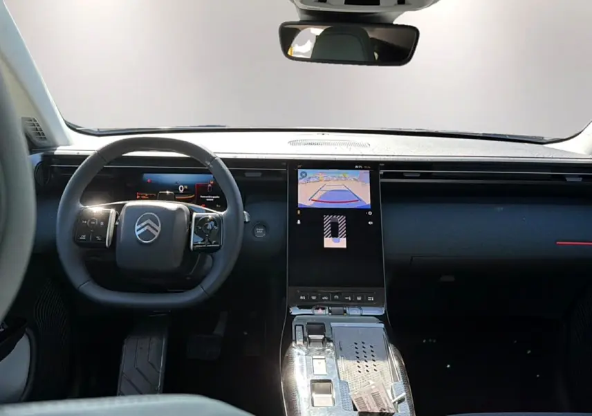 Vue intérieure avant du Citroën C5 Aircross hybride 2026, volant multifonction et écran tactile central allumé.