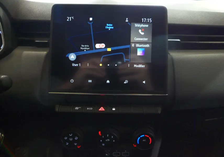 Écran tactile central avec navigation et commandes climatisation dans l'habitacle d'une Renault Clio V blanche.