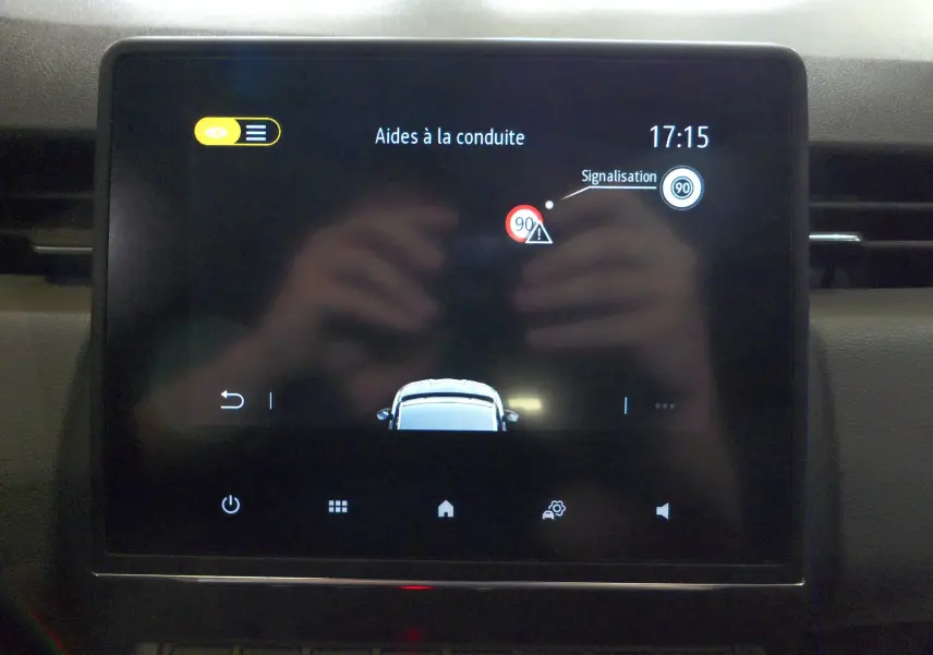 Écran tactile intérieur de la Renault Clio V Société blanc glacier affichant les aides à la conduite et la signalisation.