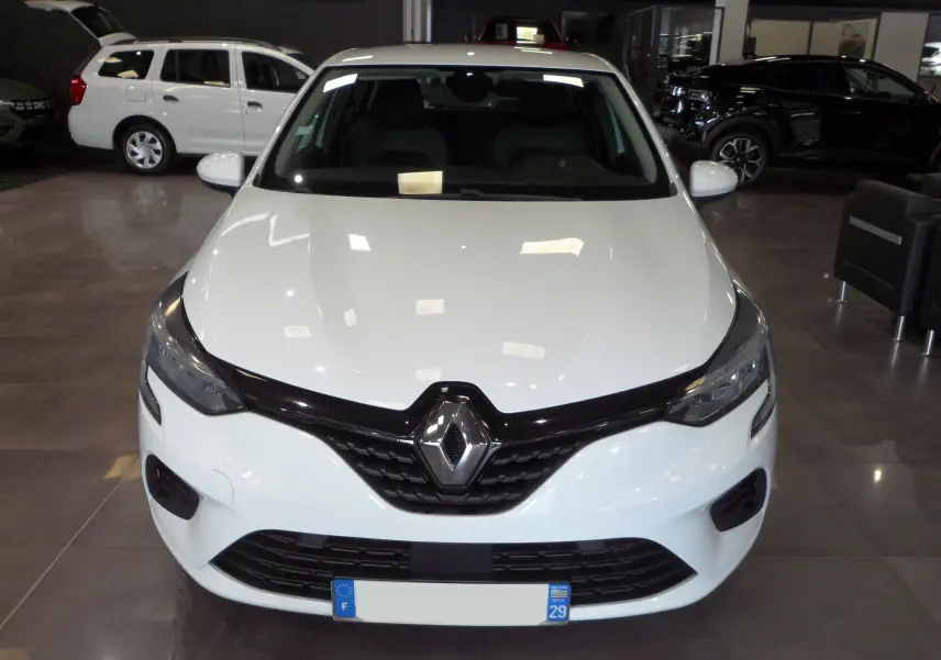 Vue frontale d'une Renault Clio V blanche Glacier en showroom, soulignant sa calandre noire distinctive et ses phares modernes.
