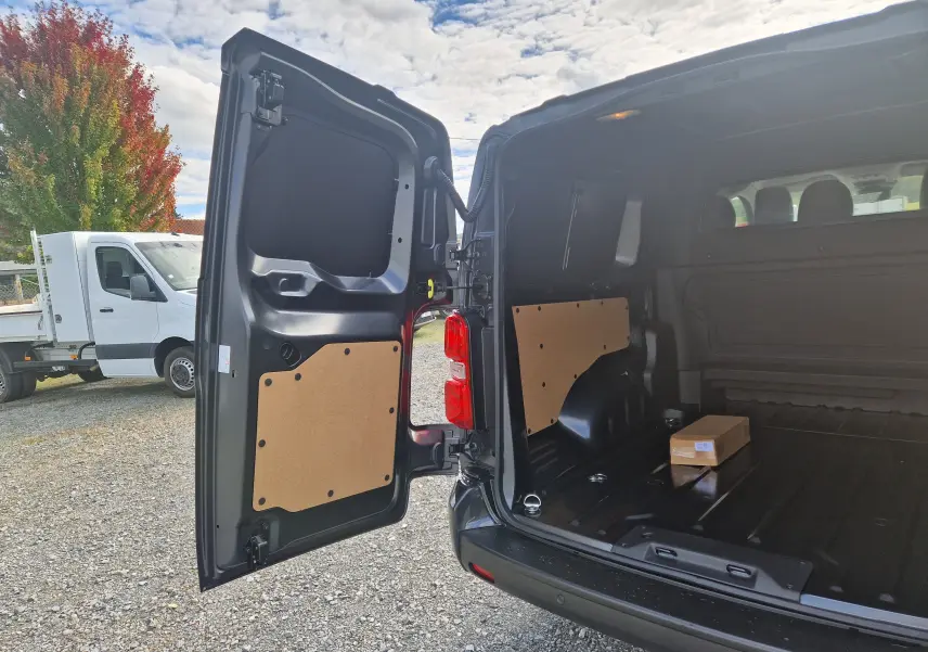 Vue arrière ouverte du Citroën Jumpy XL gris titane montrant l'espace de chargement avec un carton à l'intérieur.