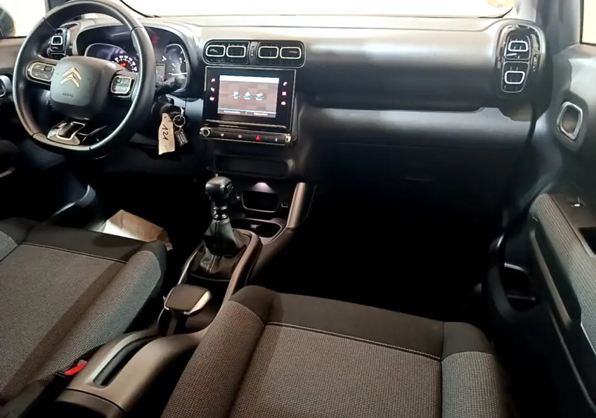Intérieur noir du Citroën C3 Aircross 2019, vue du tableau de bord et volant côté conducteur avec écran tactile central.