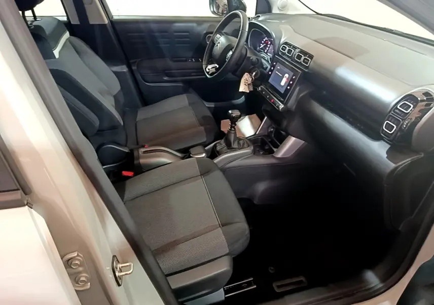 Intérieur avant droit du Citroën C3 Aircross blanc 2019, montrant sièges noirs, tableau de bord et écran tactile central.