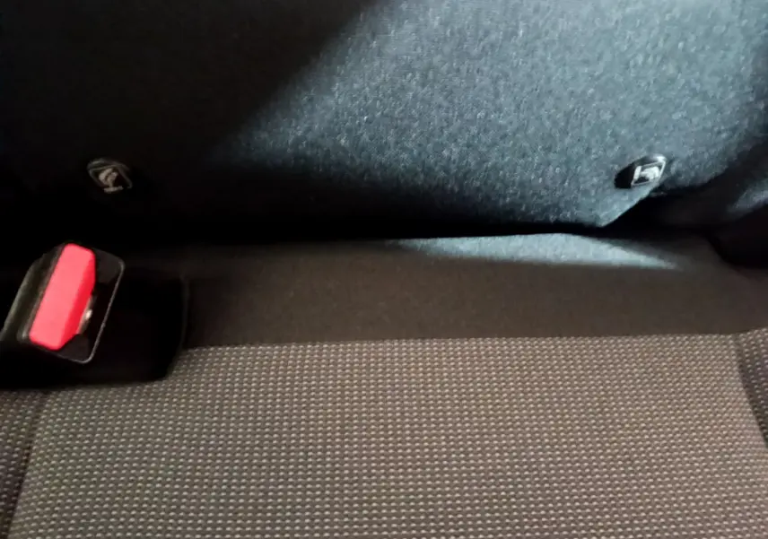 Gros plan sur la banquette arrière noire et la ceinture de sécurité rouge d'une Citroën C3 Aircross blanche.