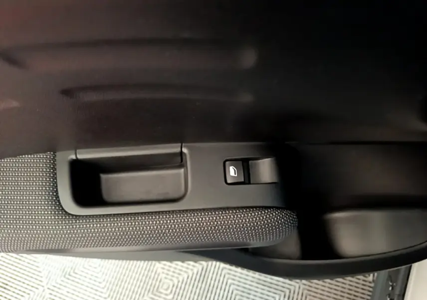 Poignée intérieure et commande de lève-vitre côté gauche d'une Citroën C3 Aircross blanche, finition Feel Business.