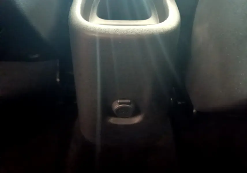 Prise 12V noire vue en gros plan sur la console centrale arrière d'un Citroën C3 Aircross blanc.