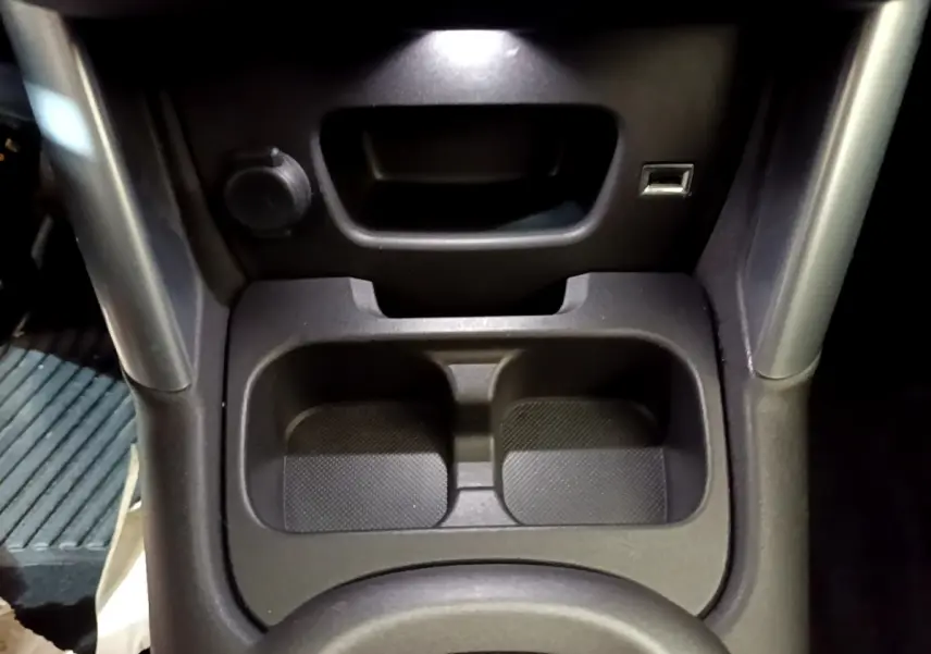 Gros plan sur le rangement central avant avec prise USB et allume-cigare dans le Citroën C3 Aircross blanc.