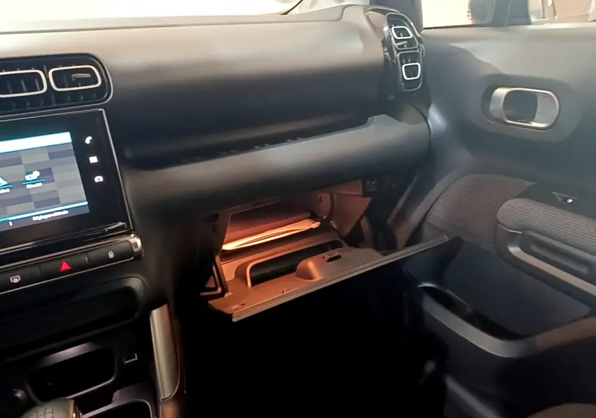 Intérieur du Citroën C3 Aircross blanc 2019, vue côté passager avec boîte à gants ouverte et écran tactile visible.