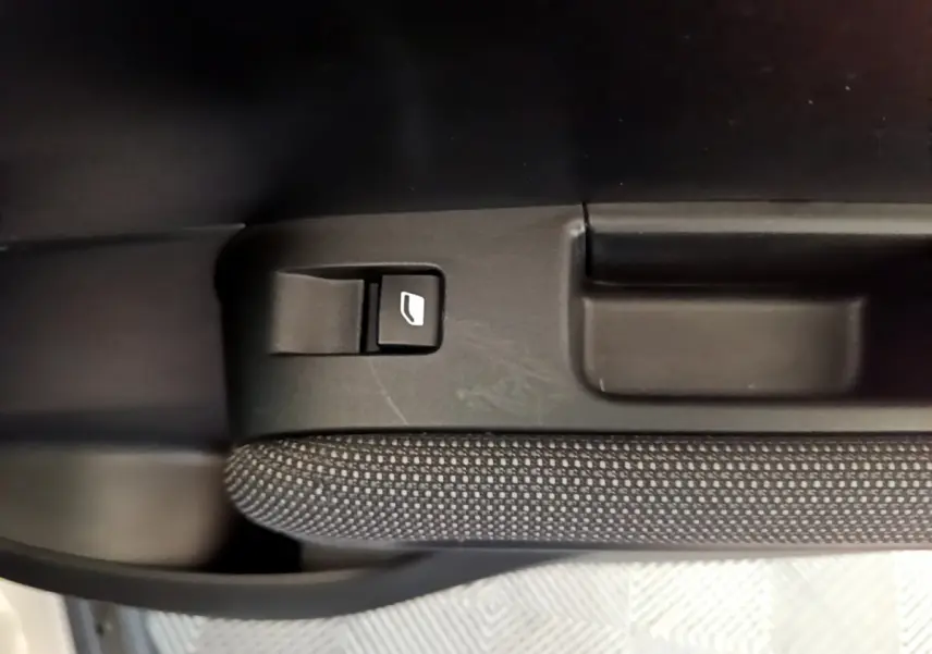 Bouton de commande de lève-vitre sur la porte côté gauche intérieure d'une Citroën C3 Aircross blanche de 2019.