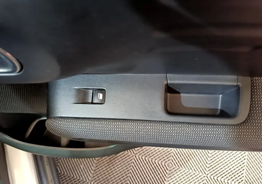 Gros plan sur la commande de lève-vitre côté conducteur dans l'intérieur noir du Citroën C3 Aircross blanc.