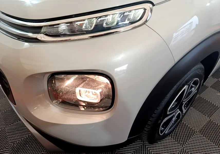 Gros plan sur l'avant droit blanc du Citroën C3 Aircross avec feux LED et antibrouillard allumé.